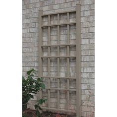 an old window is sitting on the side of a brick building next to a potted plant