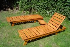 two wooden chaise lounges sitting in the grass