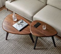 two coffee tables sitting on top of a carpeted floor next to a couch and table