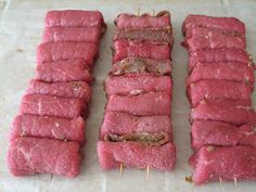 several pieces of meat sitting on top of a cutting board with toothpicks sticking out of them