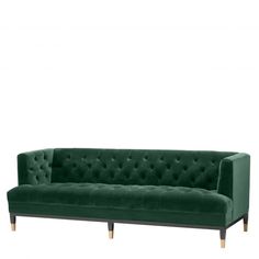 a green velvet sofa with wooden legs and buttons on the back, in front of a white background