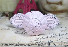 two pink knobs sitting on top of a piece of paper with the eiffel tower in the background