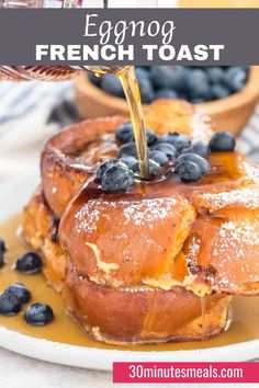 french toast with blueberries and syrup being drizzled on top