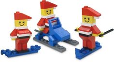 three lego figures in different poses on skis