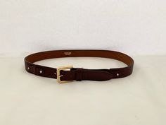 "This is a Metropolitan, genuine leather belt in a rich mahogany brown. It is accented with a gold buckle and silver studs securing decorative leather joiners. Metropolitan leather is produced by the British United Shoe Machinery Company in Leicester, UK which has been in business for over 100 years. If you purchase more than one item from my shop in the same order, I will automatically combine shipping costs and refund your overage.  You can browse my shop at www.etsy.com/ca/shop/trinketsntreas Leicester Uk, Belt With Gold Buckle, Mahogany Brown, Feathered Hairstyles, Genuine Leather Belt, Suspender Belt, Suspenders, Silver Studs, 100 Years