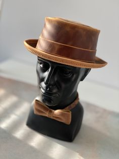 Add a touch of vintage style to your outfit with this handmade pork pie hat and bow tie set, crafted from genuine Crazy Horse leather.  This set is perfect for: - Special occasions such as weddings, proms, and formal events - Adding a touch of sophistication to your everyday look - A unique and thoughtful gift for the man in your life HAT SIZE: We will sew a hat, especially for you, according to the size of your head. How to know your size? Measurements should be made directly above the ears - this will be a conditional line of the landing of your hat.  Repeat the measurement several times - around the widest part of the head.  The head circumference in centimeters will be the size of your hat. BOW TIE SIZE: 4,7 x 2.4 inch (12cm x 6cm) The bow tie has an adjustable strap for a comfortable Sew A Hat, Pork Pie Hats Men, Paperboy Hat, Pork Pie Hat, Pork Pie, Bow Tie Set, Leather Coin Purse, 2024 Wedding, Men In Uniform