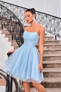 a woman in a short blue dress standing on stairs