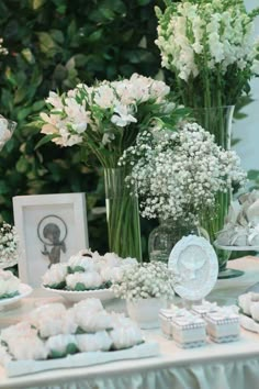 a table topped with vases filled with white flowers