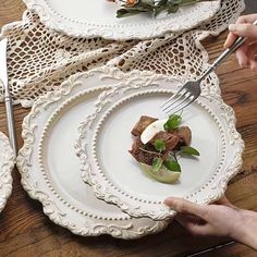 two plates with food on them, one being cut into pieces and the other is holding a fork