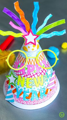 a paper party hat with streamers and confetti on it for a new year's eve celebration