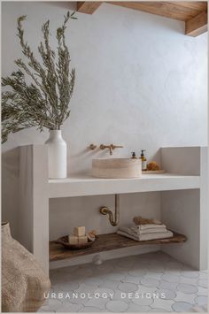 a bathroom with a sink, mirror and vase on the shelf next to each other