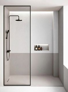 a white bathroom with a shower, sink and shelf in the corner next to it