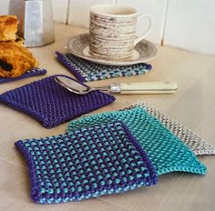 three crocheted placemats on a table next to a coffee cup and spoon