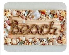 the word beach spelled in rope surrounded by sea shells and seashells on a wooden board