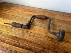 an old wooden table with metal handles on it and wood grain flooring in the background