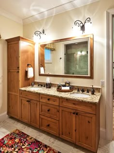 a bathroom with two sinks and a large mirror in it's center area, along with a walk - in shower