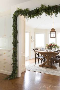 the dining room table is decorated with greenery