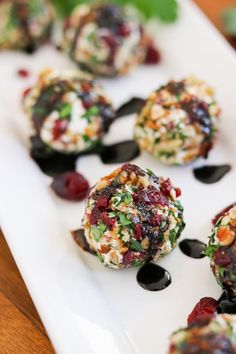 small appetizers on a white plate with blueberries and other toppings are displayed