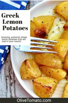 a white plate topped with potatoes covered in cheese and seasoning next to a fork