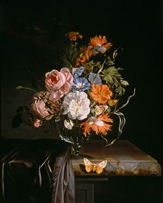 a vase filled with lots of flowers on top of a table