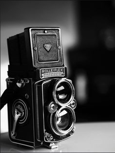 a black and white photo of an old camera with the words life is like a camera