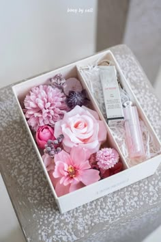 a white box with pink flowers and other items in it