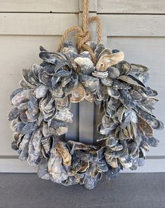 a wreath made out of seashells hanging on a door