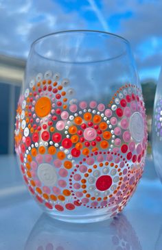 two glass vases sitting on top of a white table covered in dots and circles