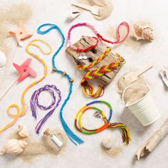 there are many different items on the sand and one has a straw cup in it