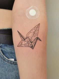 an origami bird tattoo on the arm