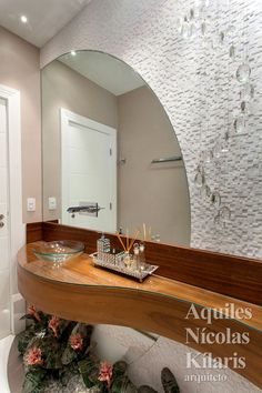 a bathroom with a large mirror above the sink and wooden counter top in front of it