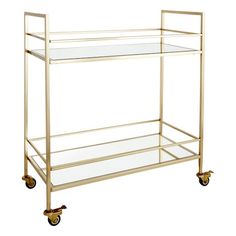 a gold bar cart with glass shelves and casteors on wheels, against a white background