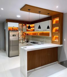 a kitchen with an island, refrigerator and sink in it's center area is lit by recessed lights