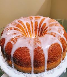 a bundt cake sitting on top of a white plate next to a glass table