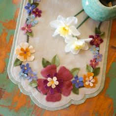 an embroidered table runner with flowers on it