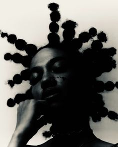 a black and white photo of a woman with dreadlocks