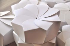 many white boxes are stacked on top of each other in order to be made into an origami flower