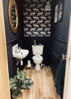 a bathroom with black walls and wooden floors