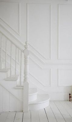 an empty room with white walls and stairs