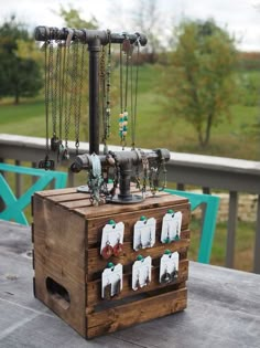 a wooden box sitting on top of a table filled with necklaces and other items