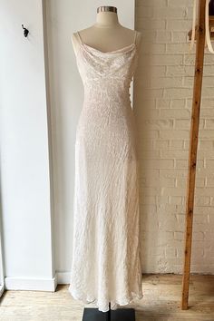 a white dress on display in front of a brick wall