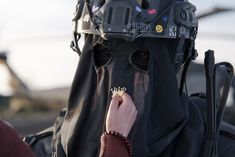 a person wearing a black mask and holding something in their hand