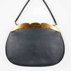 "FREE DOMESTIC SHIPPING! Round Black Leather Handbag by Creaciques Helen Exclusiva Liverpool  ERA: vintage 50s SIZE: 9\" tall x 12\" wide x 2.5\" deep COLOR: black + brass-tone HANDLE: top handle (4.5\" drop) EXTERIOR: smooth genuine leather surface + shiny brass/gold-tone metal accents + unique oval / round shape INTERIOR: fully lined + 1 zip pocket + 1 welt pocket HARDWARE: clasp closure + frame opening + 4 metal feet on the base CONDITION: This vintage bag has distressed over time and shows natural signs of wear including: SCRATCHES AND SCUFFS ON THE METAL AND LEATHER + INTERIOR DISCOLORATIONS. It is in good vintage condition overall. Please look closely at photos for details and contact me with questions. FUNCTION: handbag, purse, top handle, hard sided STYLE: retro, art deco, mod, mid Retro Evening Bag With Brass Hardware, Vintage Shoulder Bag With Brass Hardware For Evening, Retro Evening Bags With Brass Hardware, Vintage Evening Bags With Brass Hardware, Black Leather Handbag, Vintage Bag, Metal Accents, Black Leather Handbags, Black And Brass