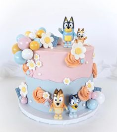 a cake decorated with cartoon characters and balloons