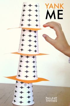 a hand is reaching up to make a paper cone with black and white stars on it