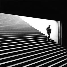 black and white photograph of man walking up stairs