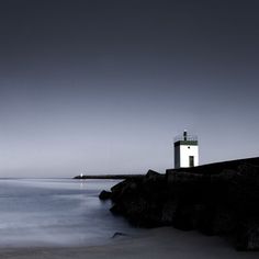 a light house sitting on top of a rocky shore