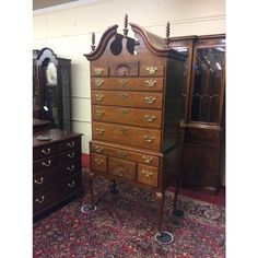 an old wooden dresser sitting on top of a carpeted floor next to a mirror