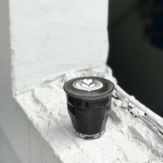 there is a cup that has been placed on the ledge