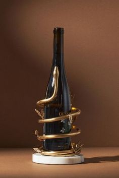 a wine bottle is wrapped in gold ribbon and sitting on a table with a brown background